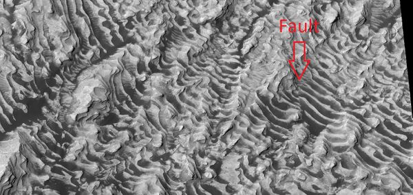 Layers on the floor of Danielson Crater taken under the HiWish program Arrow indicates area of a fault.